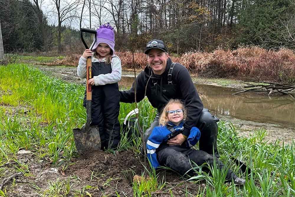 Mike Sklad and daughters at community dam restoration planting at Naftelâ€™s Creek.
